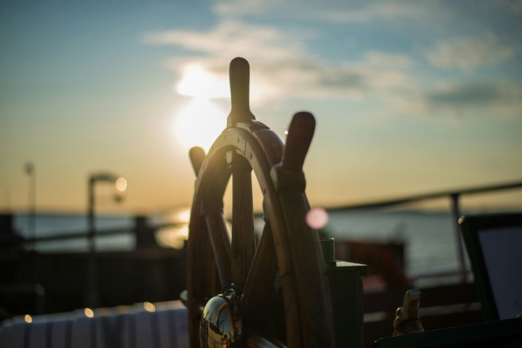 Stuur van een boot met de zon op de achtergrond